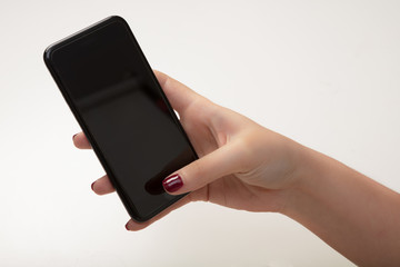 Woman text messaging on a mobile phone in a close up view of her hands and the blank screen