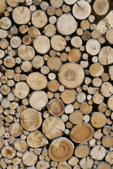 Sawn timber logs prepared and stacked for a wood burning stove. Close up in full frame and a vertical format. Timber industry concept. 
