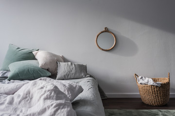 Bett mit Bettwäsche in Pastelltönen und Dekoration aus natürlichen Materialien