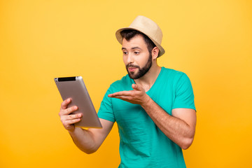 I love you! Happy caress enamored guy using digital tablet for chatting with lover, he is sanding her air kiss isolated on bright yellow background