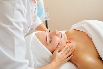 Fototapeta na wymiar Beautiful woman at a facial massage at a spa salon.