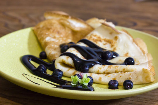 Thin French pancakes decorated with chocolate and fresh berries.