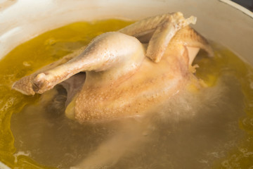 Boiled chicken in a pot of boiling water