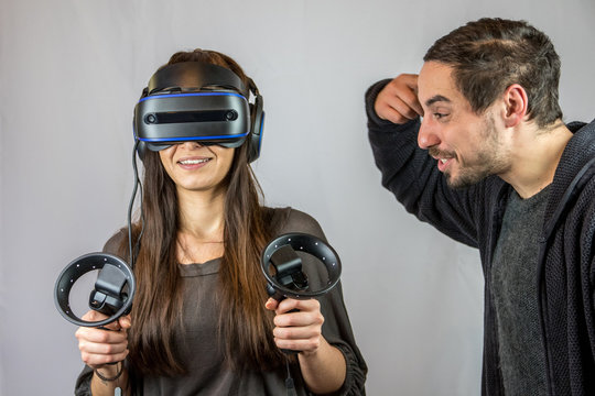 Junge Frau spielt mit Virtual Reality Datenbrille, Freund zeigt Vogel