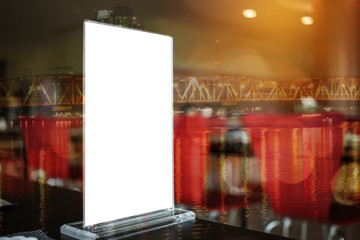 Mock up white Label on the table for blank menu frame in restaurant for booklets with sheets paper, Stand for acrylic tent card Used for Menu Bar, blur of light background insert for text of customer.