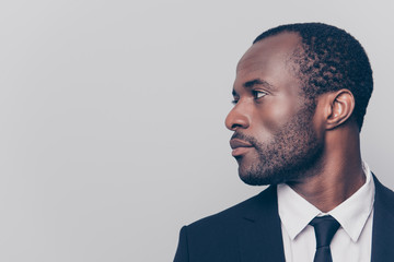 Half-turned side profile close up view portrait of handsome virile masculine attractive confident smart intelligent clever african man looking aside weairng smartsuit isolated on gray background - Powered by Adobe