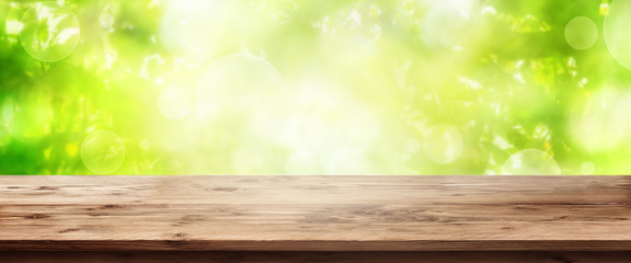 Naklejka na ściany i meble Abstract green background with wooden table