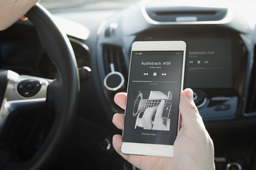 Listening music. Smart phone connected to car audio system.