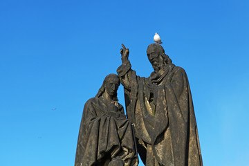 Pigeon sitting on sculpture's head on Charles Bridge, Prague, Czech Republic