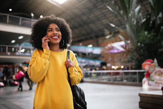 Beautiful afro woman using mobile in the train station.