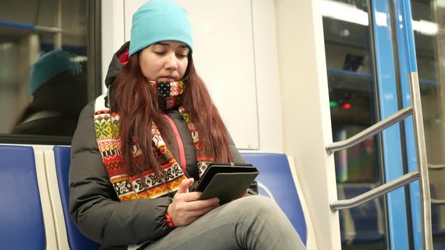 Young woman read e-book in subway train at metro
