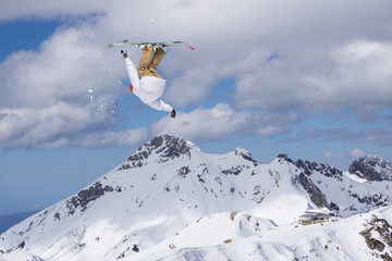 Naklejka na ściany i meble Skier jump in the mountains. Extreme ski sport. Freeride.