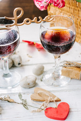 Wooden word LOVE standing on glasses of wine