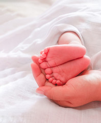 mother holding baby feet