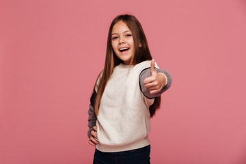 Happy brunette girl showing thumbs up and smiling to camera isolated