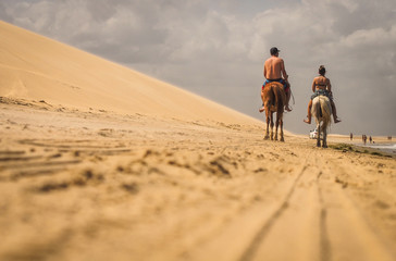 horse riding in sand dunes at the beach