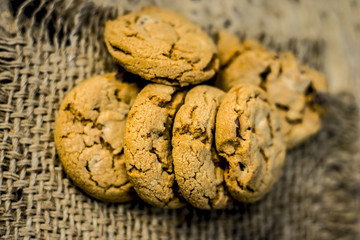 Homemade freshly baked chocolate chip cookies on gunny background.