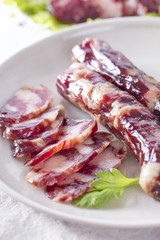 Close-up of cold cuts and vegetables on a plate. Raw pork sausage.