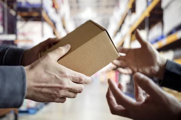 Photo sur Plexiglas Bâtiment industriel Worker with package in a distribution warehouse