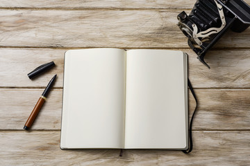 blank notebook, pen and old camera
