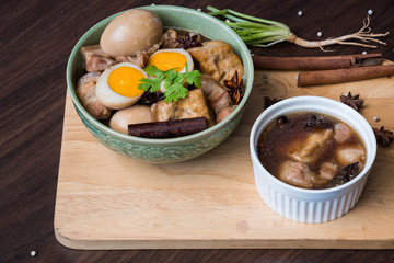 Pha-lo : Eggs boiled and pork boiled with spices  and fried tofu in sweet gravy soup on wooden background. Flat lay