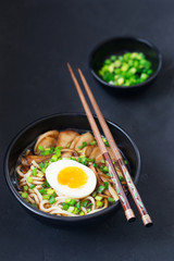 Ramen soup with mushrooms, vertical, black background