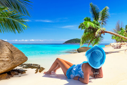 Beautiful woman in blue hat on the tropical beach
