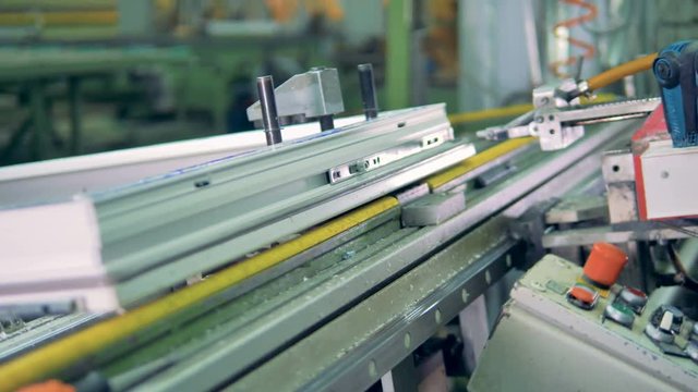 A worker installs and screws on metal bars on a window frame. 