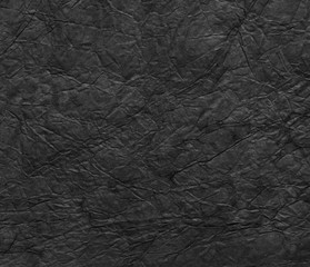 Black crumpled paper texture background.