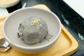 Gray ice cream with sesame in a white bowl