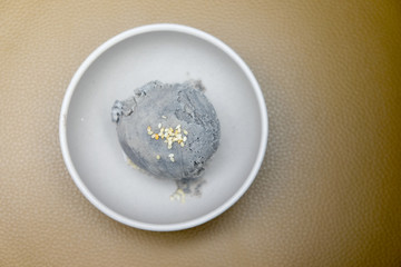 Gray ice cream with sesame in a white bowl
