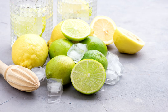 Lemonade With Citrus Lemon and Lime Detox Healthy Water Summer Cold Drink Ice Cubes Wooden Squeezer Glasses
