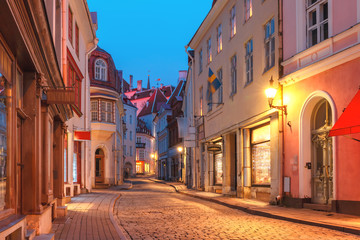 Fototapeta na wymiar Beautiful illuminated medieval street in Old Town of Tallinn during evening blue hour, Estonia