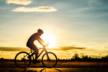 Fototapeta na wymiar Silhouette man cycling at sunset