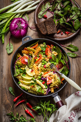 pasta salad with fresh herbs spinach, vegetables and green peas, spicy pepper
