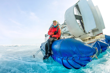girl sits on the board hovercraft ice winter lake Baikal