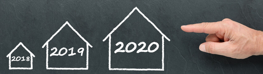 Different size houses 2018, 2019 and 2020 on a blackboard