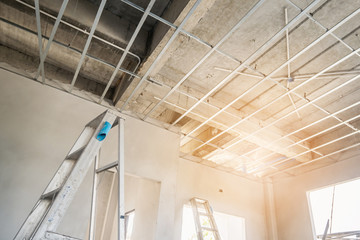 Install metal frame for plaster board ceiling at house under construction