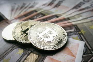 three coins bitcoin and traditional money euros