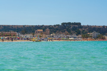 Fototapeta premium Piękna biała piaszczysta plaża w San Vito lo Capo na Sycylii z kolorowymi parasolami