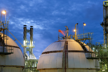 Gas storage spheres tank in refinery plant at twilight column tower background