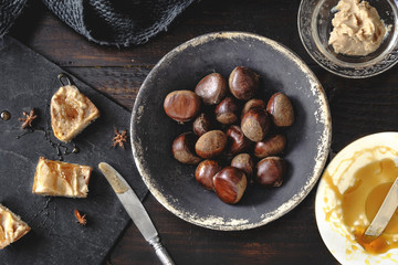 Sweet Chestnut Cream toasts with rosemary honey and anise stars. Rustic wooden background....