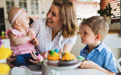 Happy and loving mother and her kids preparing home decoration