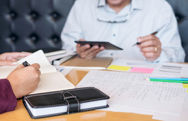 Education, teaching, learning, technology and people concept. Two high school students or classmates with helps friend catching up workbook learning in classroom, Tutor books with friends