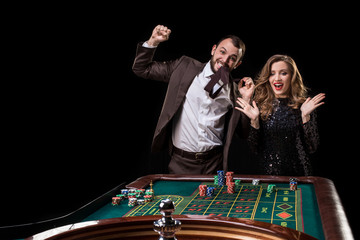 Man and woman playing at roulette table in casino