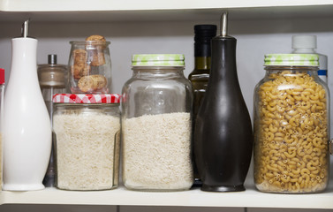 a food pantry with storage jars and rice, pasta and jasmine