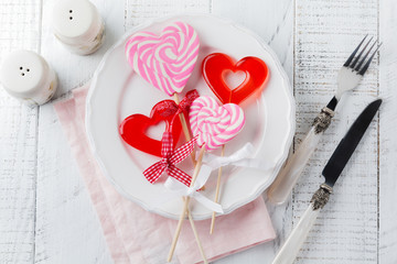 Group of festive various candies in form of  heart on white wooden background. Selective focus. Vintage Valentine card. Top view. Place for text.