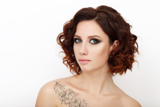 Close up beauty studio shot of beautiful redhead woman with gorgeous makeup curly hair