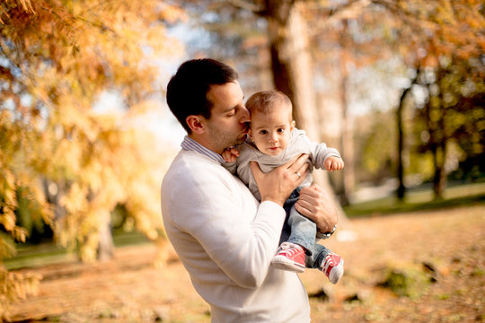 Young father and baby boy in autumn park