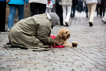 A beggar with a dog on the street of a European city